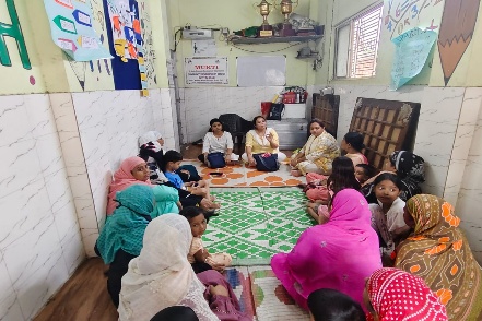 Mothers and children sitting in a circle during an MKSS caregiver meeting
